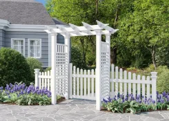 White vinyl arbour with picket gate wings and fence beside a house