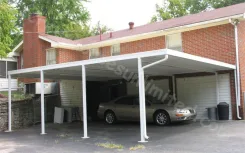 White W pan carport attached to a brick house with a car parked beneath
